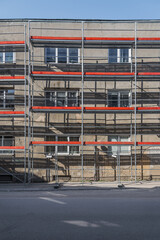 Naklejka premium Old Residential Building Renovation Site With Scaffolding In The Empty Street