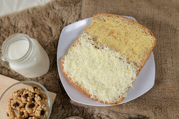 Bread with cheese, sweetened condensed milk, and butter. With white milk and snack on a table for breakfast	
