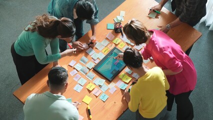 Top view of manager writing idea on sticky notes and explain idea about web design. Professional...