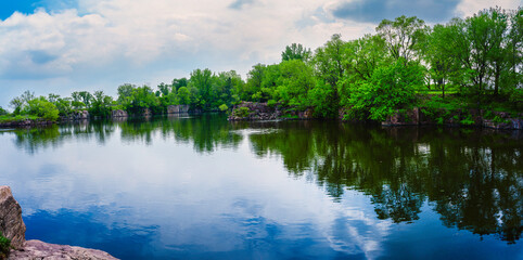 Midwestern tranquil spring landscape at Quartzite Quarry Pond in Sioux Falls, South Dakota: The...