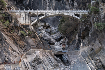 An old bridge opposite the landscape of Tiger Leaping Gorge in Yunnan province of China.