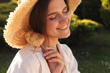 Beautiful woman with cute chick outdoors. Baby animal