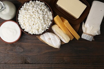 Different fresh dairy products on wooden table, flat lay. Space for text