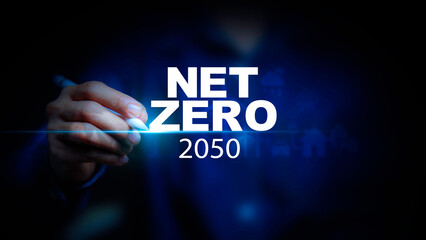 Net zero carbon neutrality  in 2050 concept. man pointing to Net zero icon at on green energy blur background. Green Energy Renewable Sustainable (ESG). Net zero emission Idea innovative.