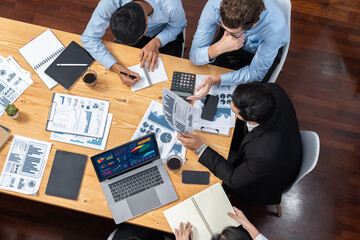 Wide top view of diverse group of business analyst team analyzing financial data report paper on...