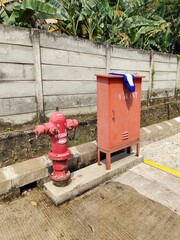 Set of Old Yet Functional Fire Hydrant Equipment with Faded Paint in an Empty Car Parking Area Next...