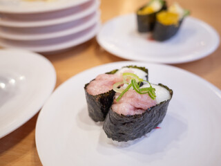 japanese traditional food sushi on the white plate at the conveyor belt sushi restaurant in japan
