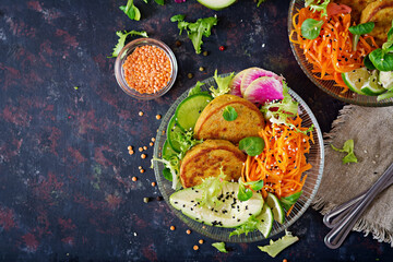 Vegan buddha bowl dinner food table. Healthy food. Healthy vegan lunch bowl. Fritter with lentils and radish, avocado, carrot salad. Flat lay