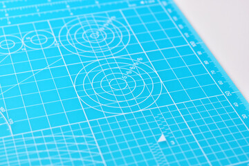 blue cutting mat board on white background with line and scale measure guide pattern for object art...