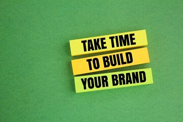 hand holding colored paper with the words TAKE TIME TO BUILD YOUR BRAND