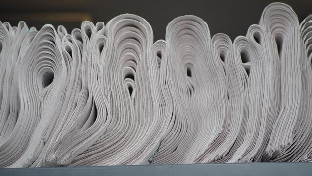 Pile of newspapers stacks on table .