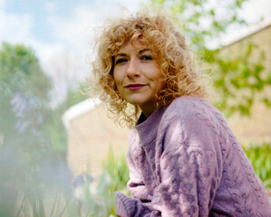 Classic analog portrait of curly woman outdoors.