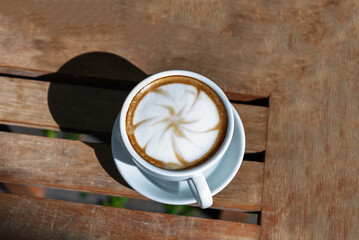 Hot latte art coffee cup on wooden table