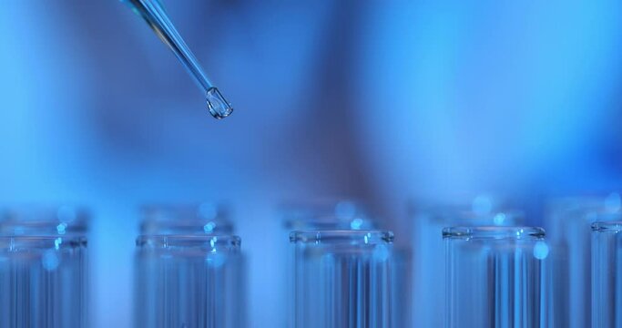 Drop of blue liquid pipettes into test tube in laboratory
