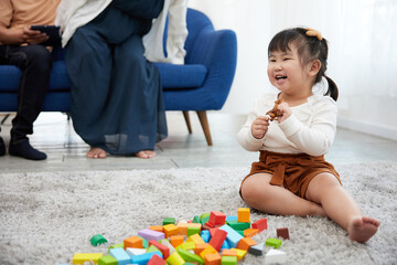 child girl feeling happy and playing with colorful toy blocks on the carpet floor