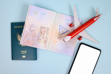 Airplane On Passport Stamp Visa With Smartphone Blank Screen Isolated On Blue Background. Mockup...