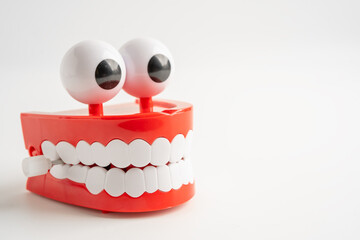 Tooth funny toy denture red color jaw and eye on whtie backgroud with copy space.
