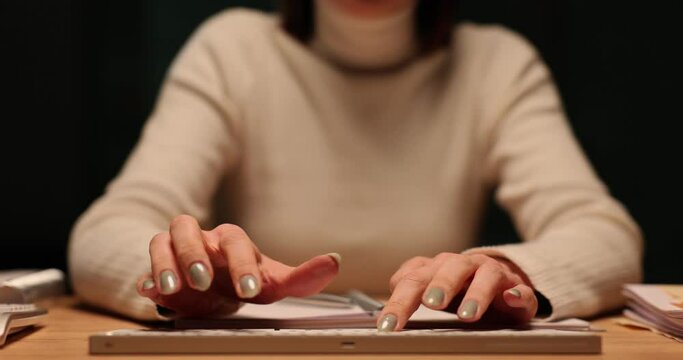 Woman types on keyboard in dark room