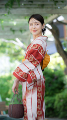 緑の屋外で浴衣を着る女性　振り返る見返り美人　縦
