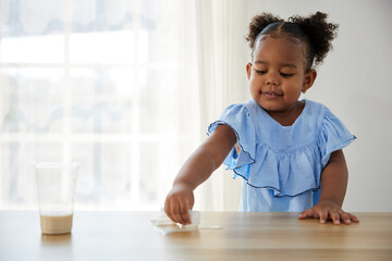 African girl using paper cleaning and wiping on the table