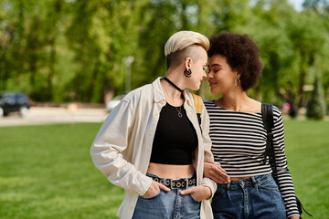 A multicultural lesbian couple, both young female students, stroll stylishly in a park near the...