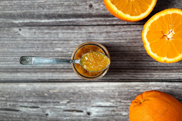 Delicious homemade orange jam. Close-up of a teaspoon over a glass jar