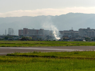 Fototapeta premium 八尾空港と畑の野焼きの風景