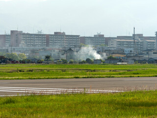 八尾空港と畑の野焼きの風景
