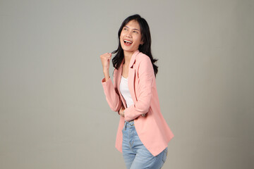 happy excited asian women cliching her fist on isolated background