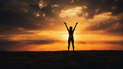 Silhouette of person celebrating at sunset with raised arms
