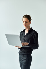 A queer person in action, using a laptop on a white background.
