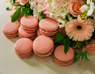 Obraz na płótnie Canvas Sweet yellow macarons or macaroons and white daisies flowers on wooden table