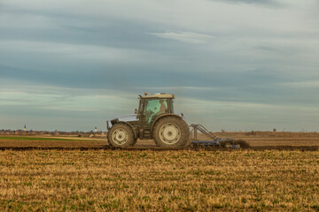 Landscape view of a farmer plowing fertile fields under a vast sky