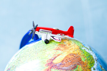 Toy airplane with propeller on top of globe model. Travel or world tour idea concept. Air...