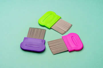 Three combs for lice removing on green background