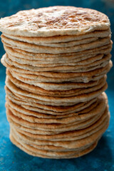 Flatbread lavash, chapati, naan, heap of tortilla on a blue background Homemade flatbread stacked.