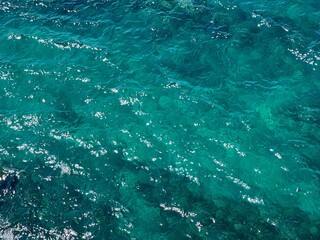 Sea blue glittering clear water background.