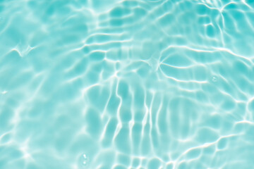 Blue water with ripples on the surface. Defocus blurred transparent blue colored clear calm water surface texture with splashes and bubbles. Water waves with shining pattern texture background.