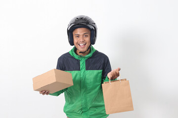 Portrait of Asian online courier driver wearing green jacket and helmet giving craft paper shopping...