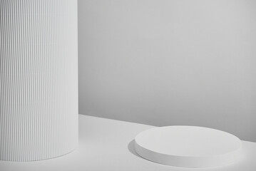 3d white ceramic display podium on table against white curtain background.