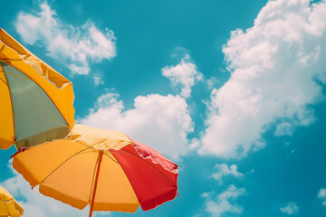 Colorful beach umbrellas against a blue cloudy sky
