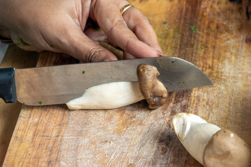 Slicing a mushroom on a kitchen cutting board