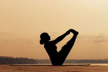 silhouette of a sporty girl doing yoga