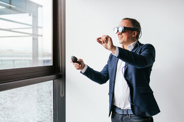 A businessman in a suit uses smart glasses and a controller, demonstrating wearable technology in a modern office.