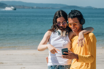 young people with headphones and phone on the beach