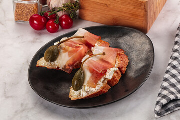 Bruschetta with jamon and caper berries