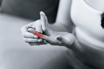 Woman suffering from hand and finger joint pain​ with red highlight.