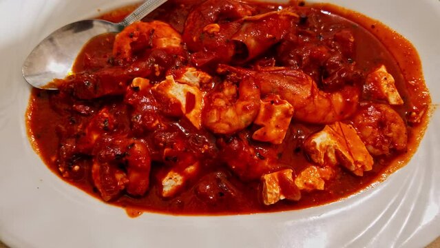 Close up shot of delicious traditional greek dish garides saganaki served in a white plate on a restaurant table in Greece. 