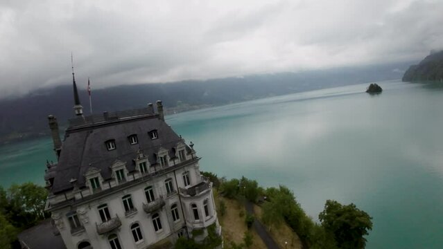 Iseltwald flight towards the castle at brienzersee lake - Aerial 4K
