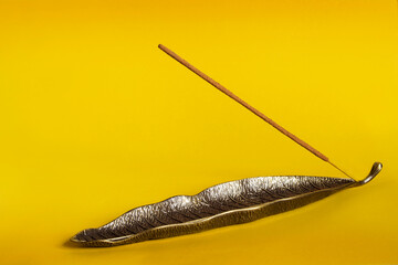 Incense stick on yellow background